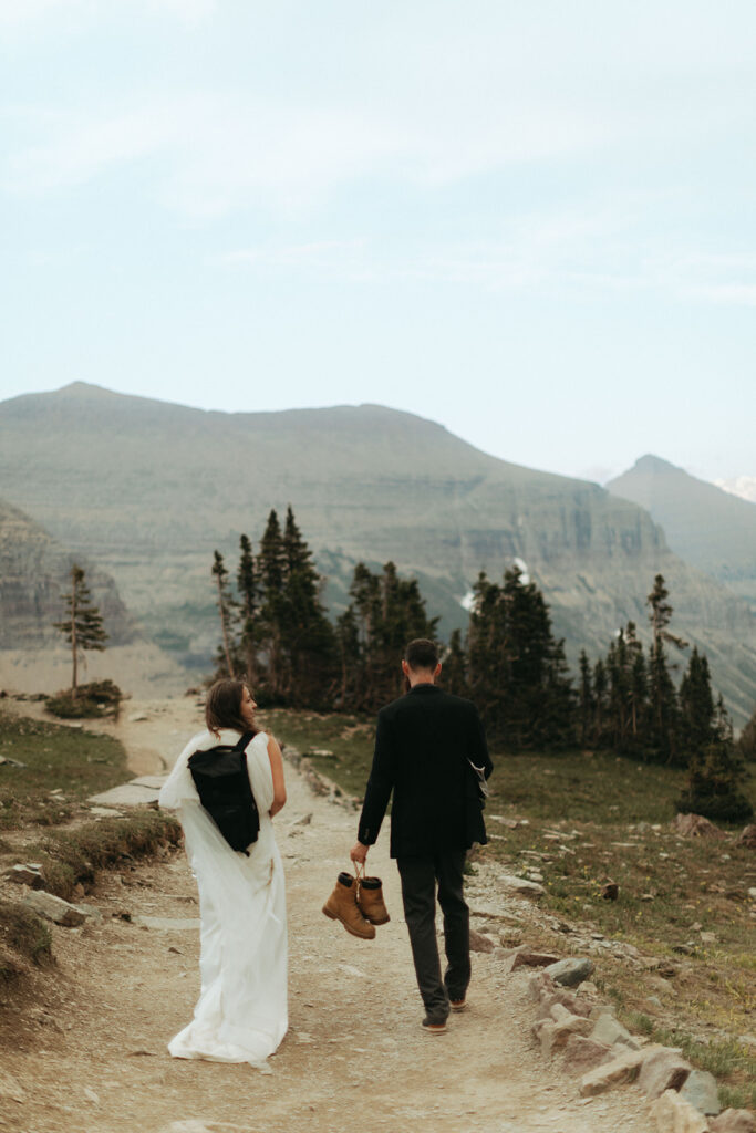 couple walks on path during glacier national park elopement