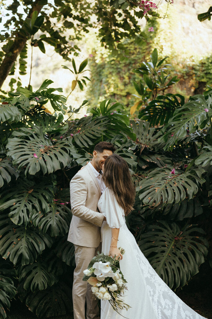 couple kisses in front of bushes at Hawaii photography content day
