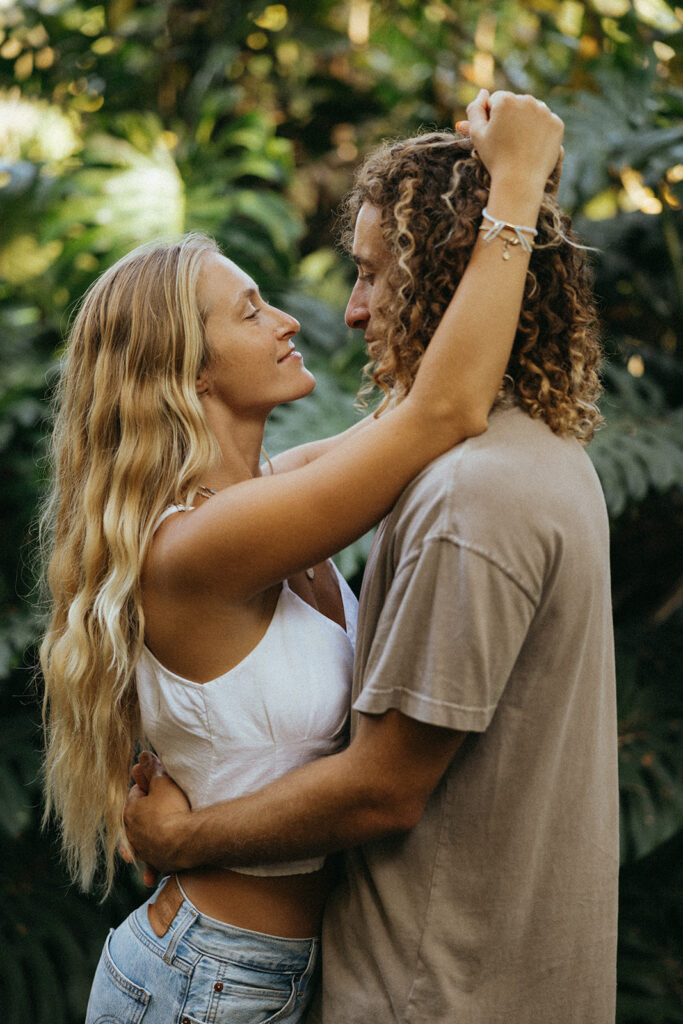 couple embraces in front of bushes at Hawaii photography content day
