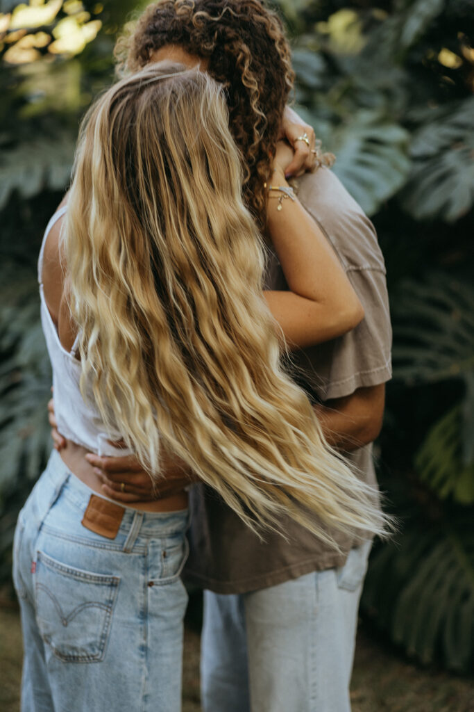 couple kisses in front of bushes at Hawaii photography content day
