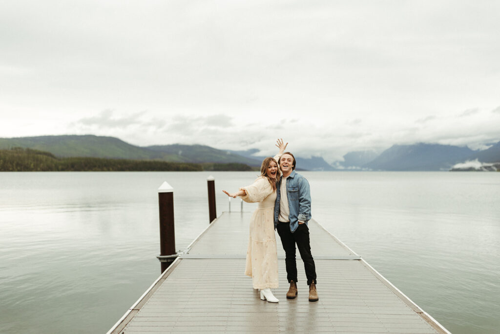 couple gets adventure ideas on pier at Glacier National Park lake