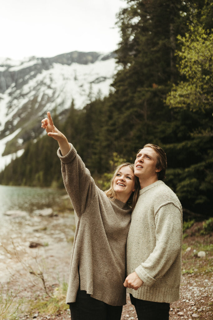 couple embraces beside lake at Glacier National Park engagement session