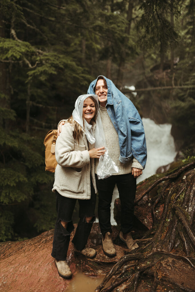 couple hugs in rain getting adventure ideas from Glacier National Park