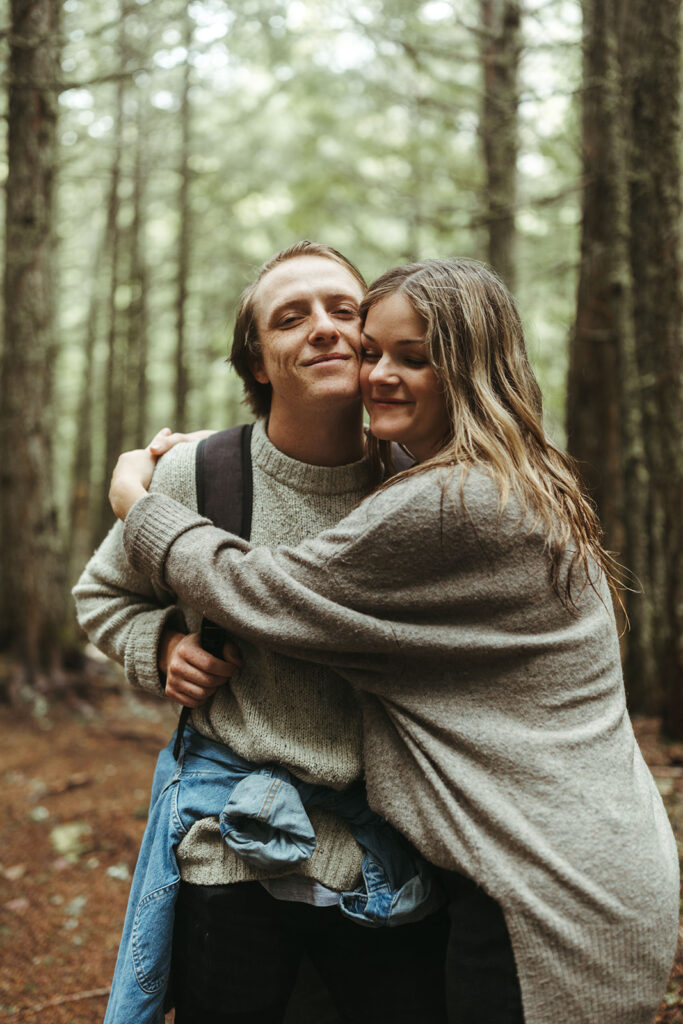 couple hugs in woods getting adventure ideas from Glacier National Park