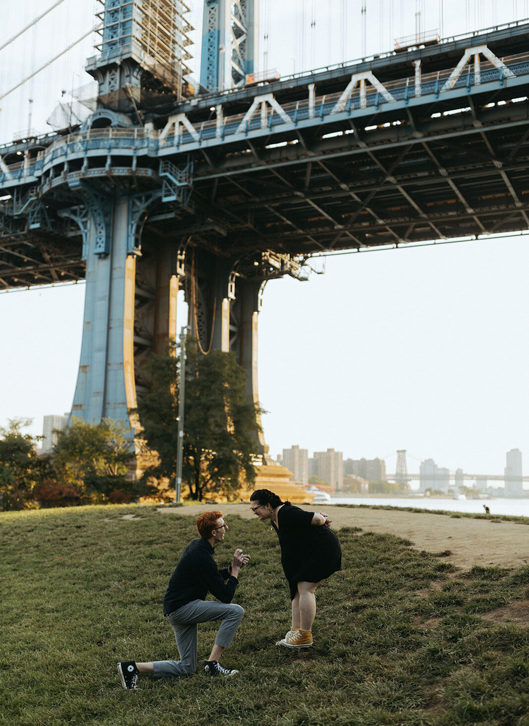 man proposes to girlfriend under Manhattan bridge