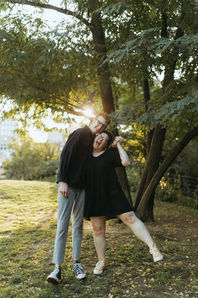 couple embraces laughing under Brooklyn tree