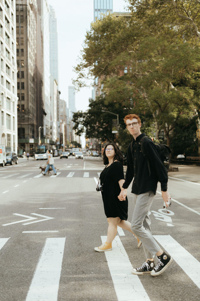couple crosses new york city street holding hands