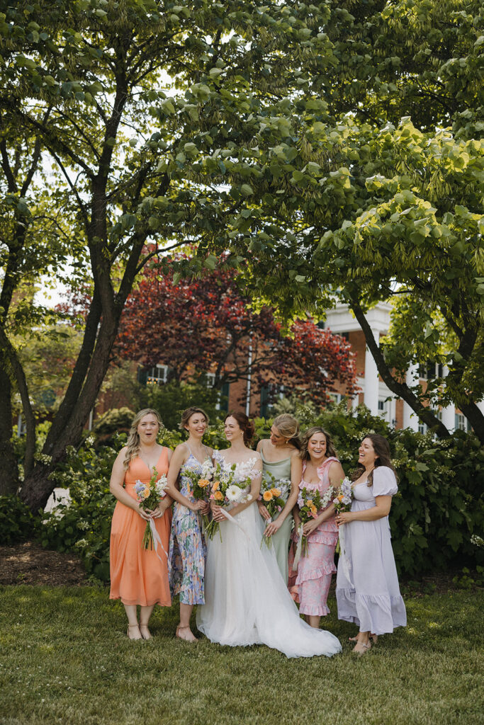 bride and bridesmaids hold wedding bouquets at garden party wedding