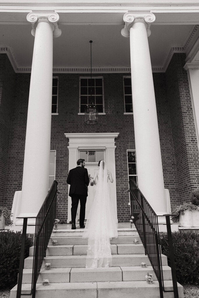 couple walks up staircase at estate wedding