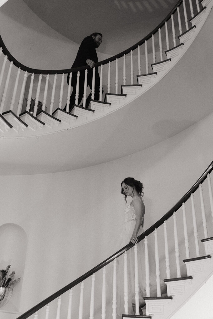 couple stands apart on spiral staircase in virginia wedding estate
