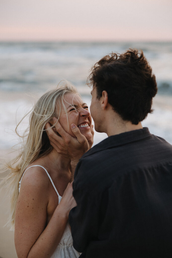 couple embraces at Virginia Beach engagement photos
