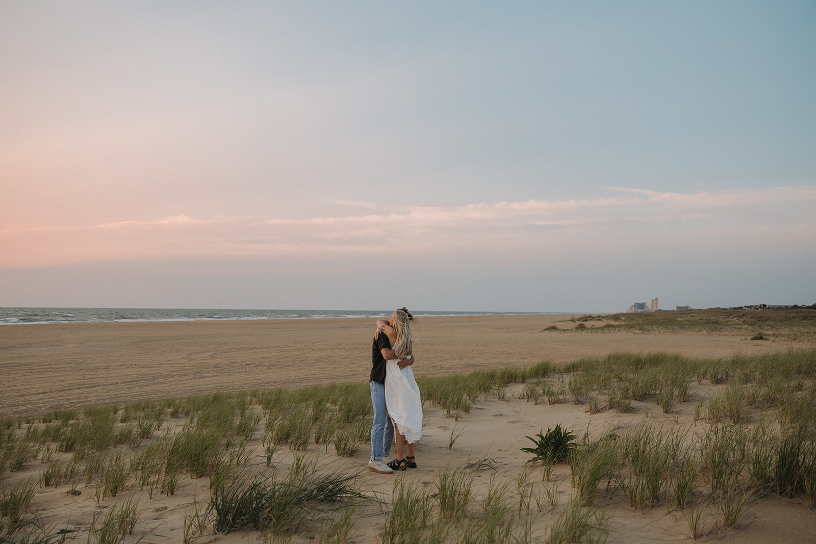couple hugs on sand at Virginia Beach sunrise engagement session