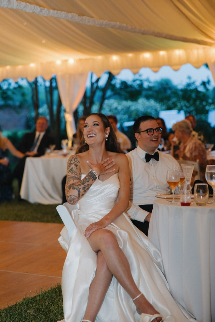 couple laughs during reception at outdoor wedding with tent
