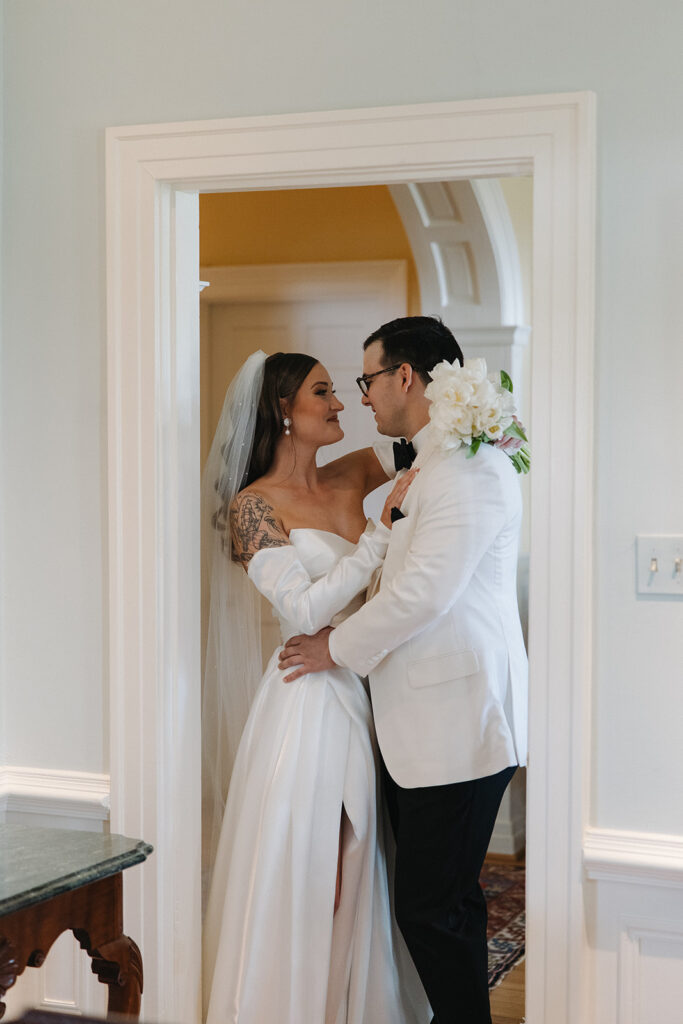 couple embraces in doorway during first look