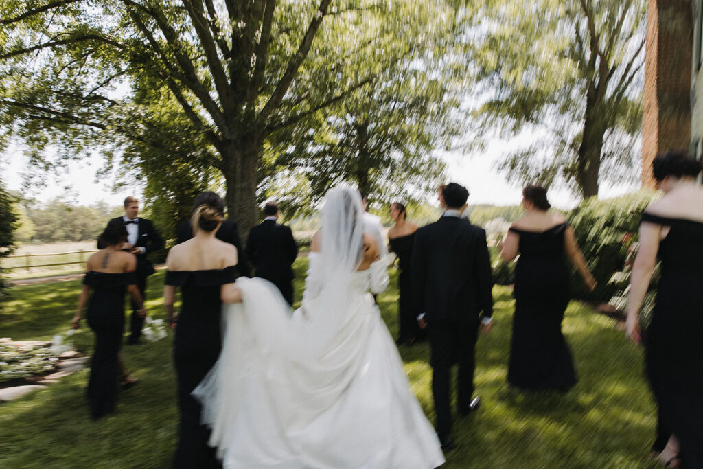 couple walks with wedding party at outdoor wedding