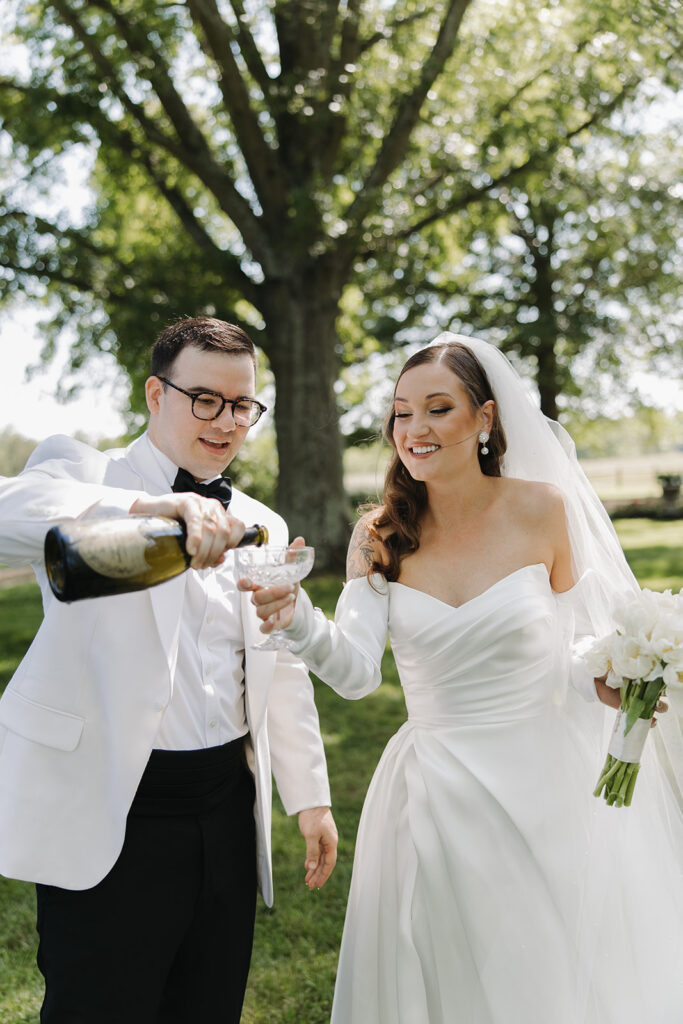 couple drinks champagne at outdoor wedding