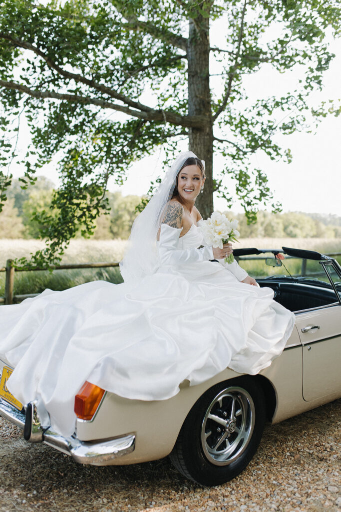 bride arrives seated in vintage car