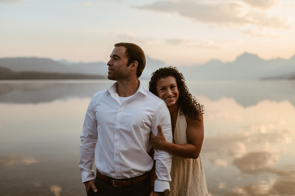 couple embraces at sunrise lake engagement session