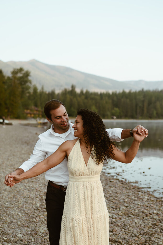 couple holds hands at Lake McDonald Glacier National Park engagement