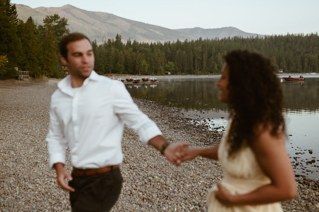 couple holds hands at Lake McDonald Glacier National Park