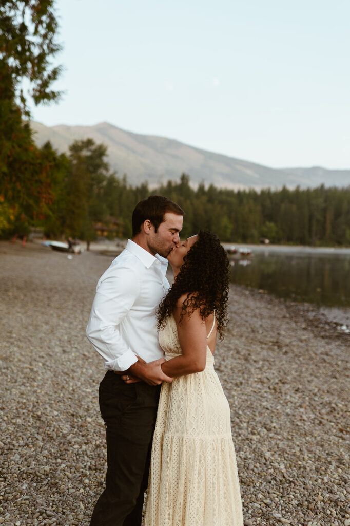 couple kisses at Lake McDonald Glacier National Park engagement