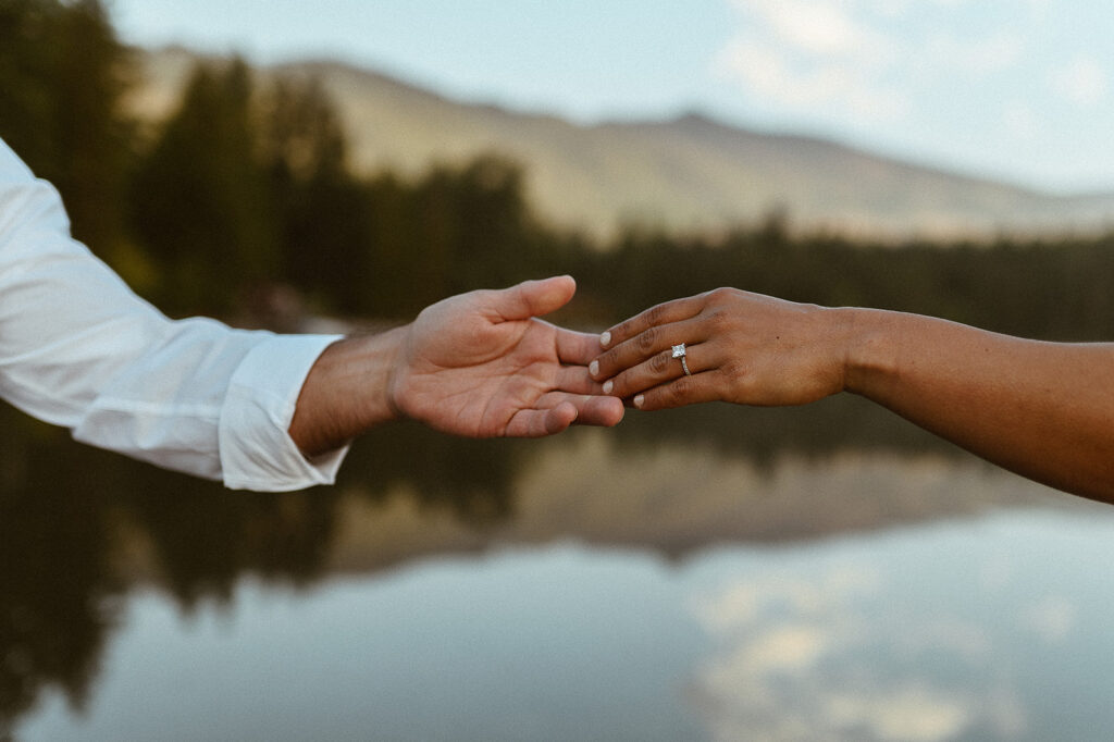 couple holds hands at sunrise engagement session