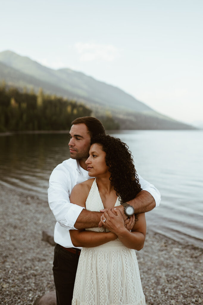 couple embraces at lakeside engagement