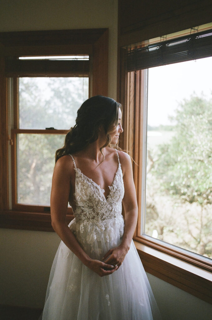 bride looks out window while getting ready