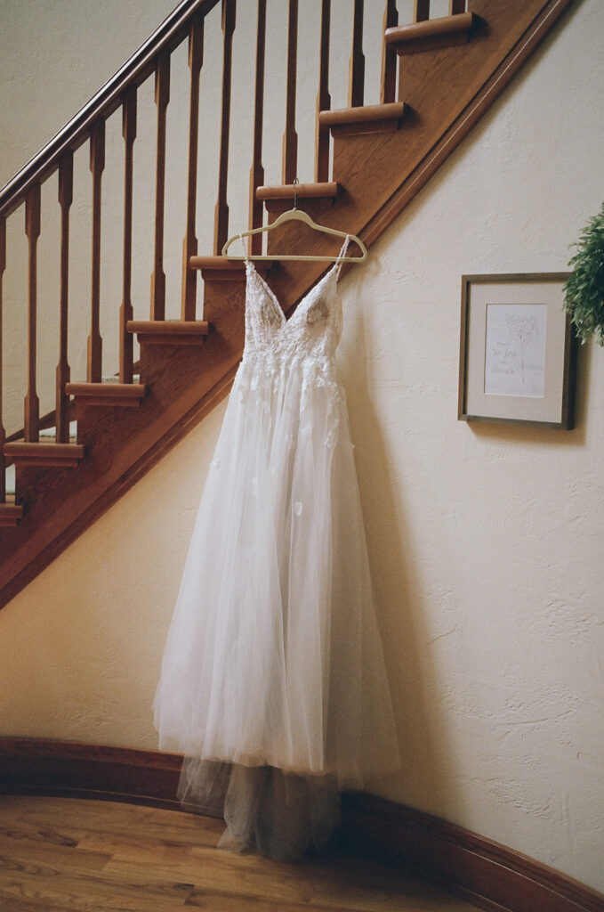 white wedding dress hangs on wall
