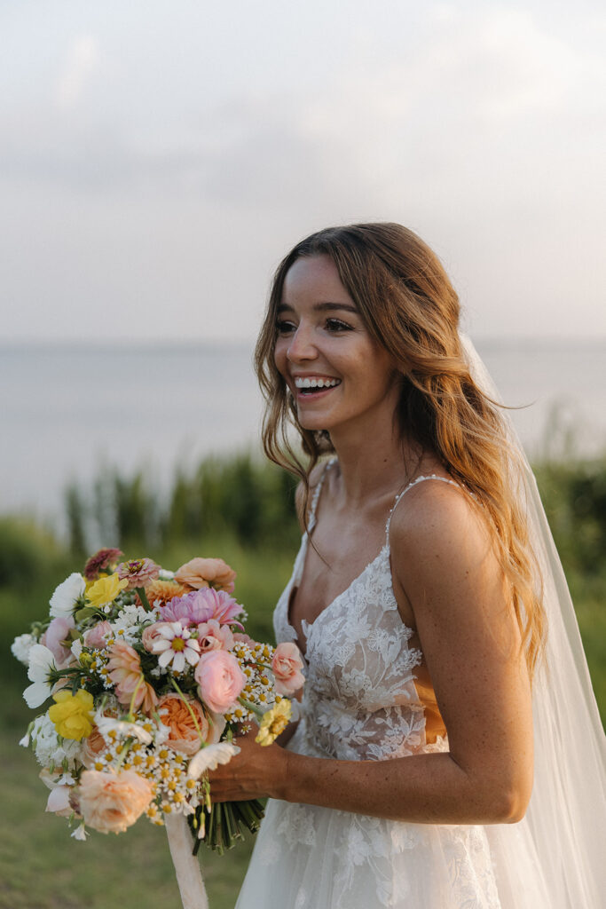 bride laughs holding wildflower wedding bouquet
