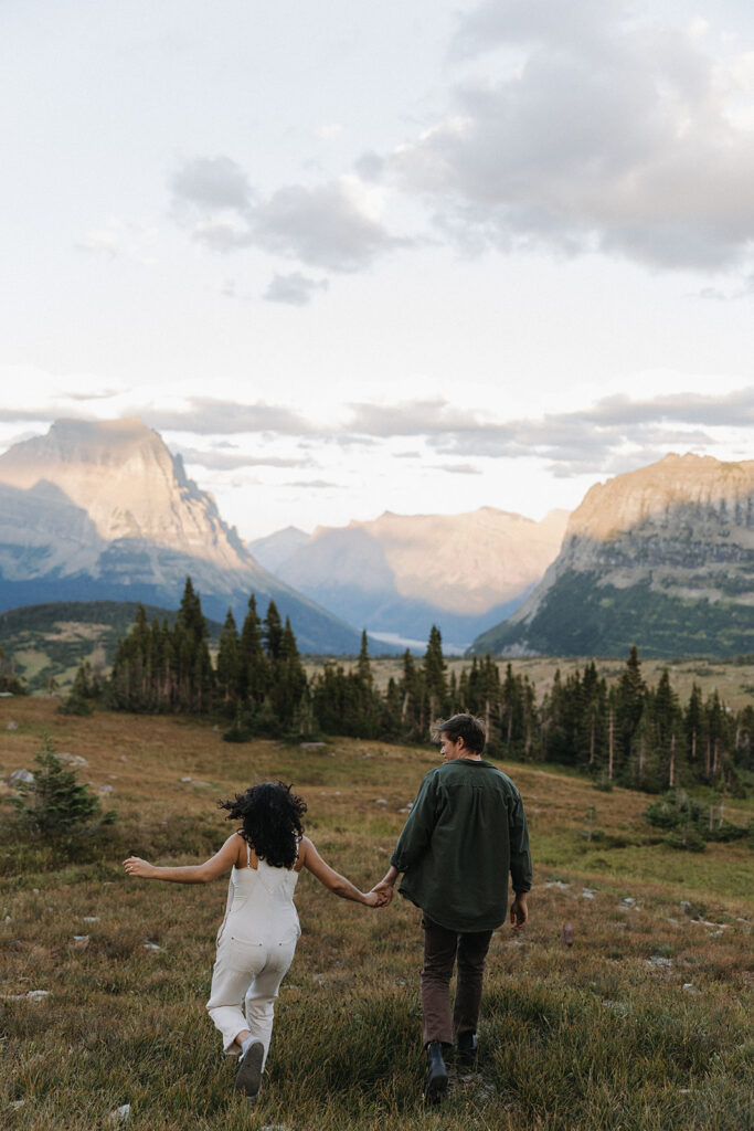 couple walks holding hands at Glacier National Park couples adventure