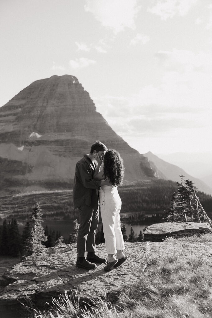 couple kisses at mountaintop engagement session