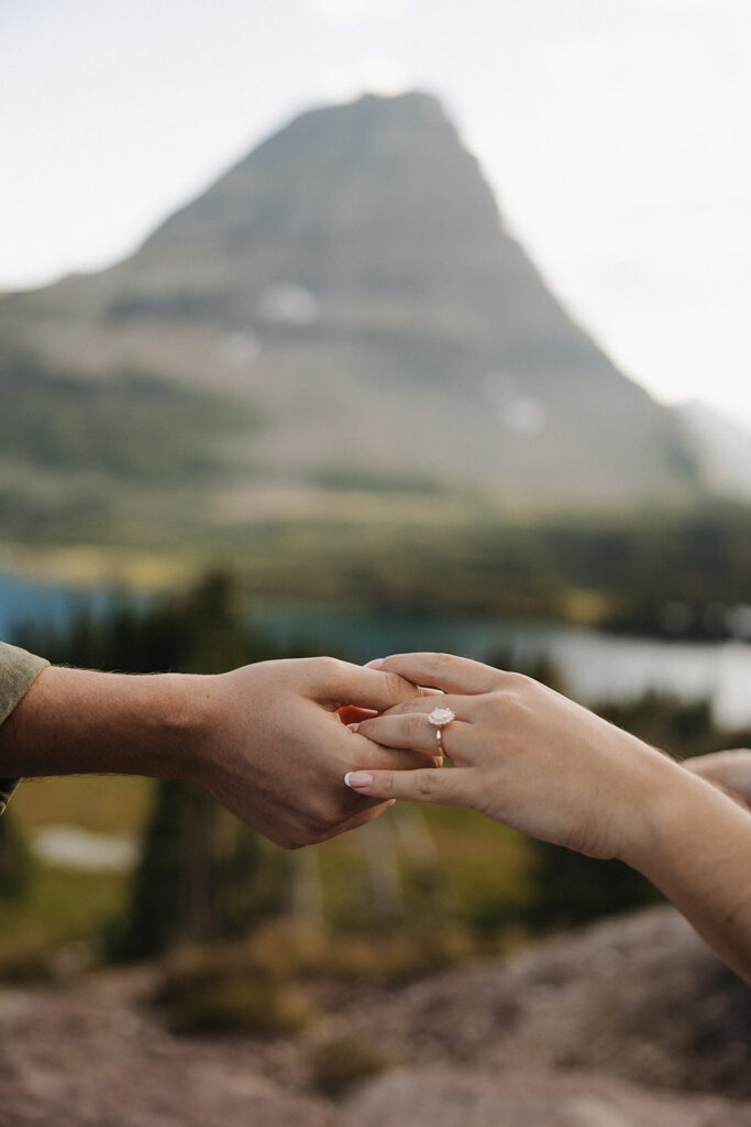 couple holds hand with engagement ring at mountain photo session