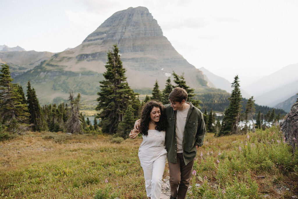 couple walks holding hands at Glacier National Park couples adventure