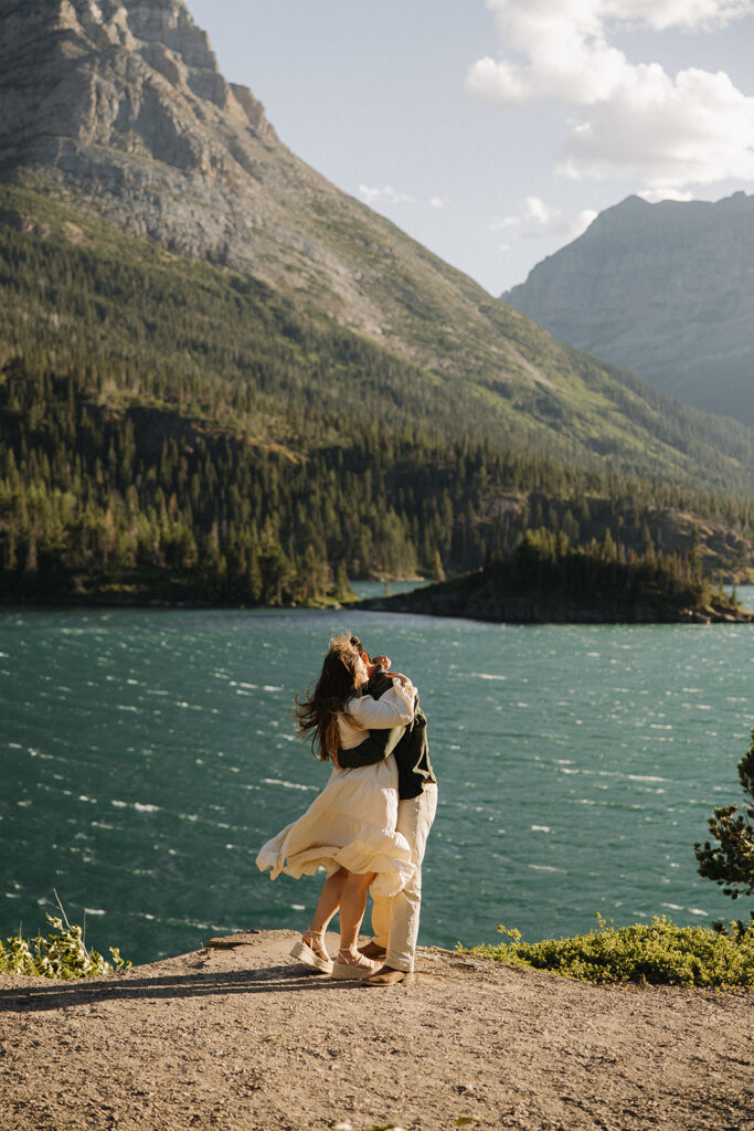 couple kisses at windy Glacier National Park engagement
