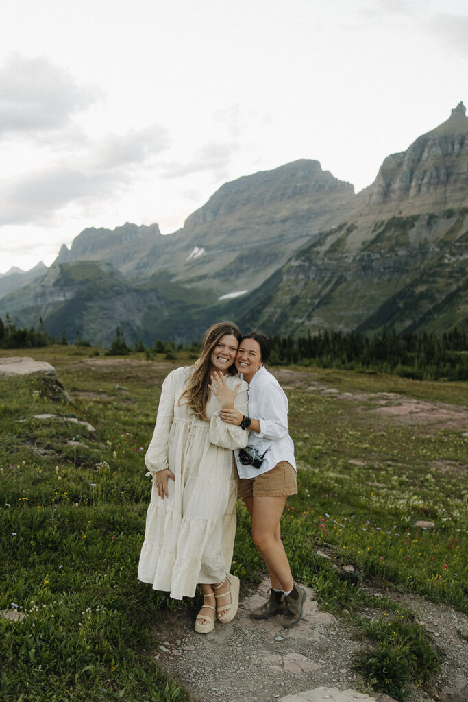 bride stands with photographer at Glacier National Park engagement