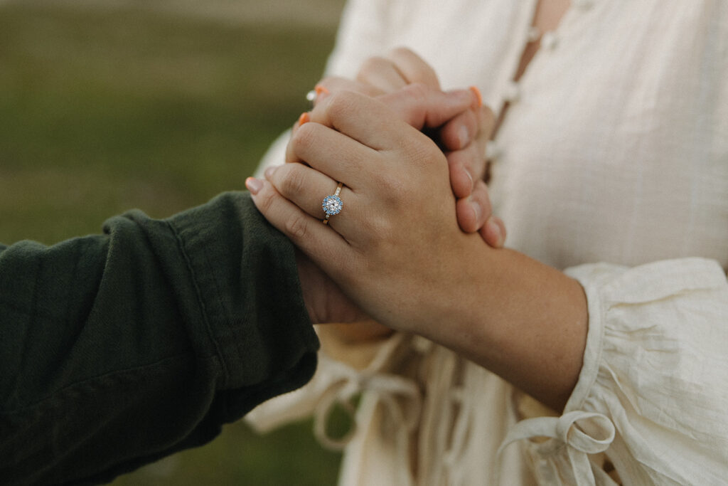 couple holds hands after surprise proposal ideas at Glacier National Park engagement