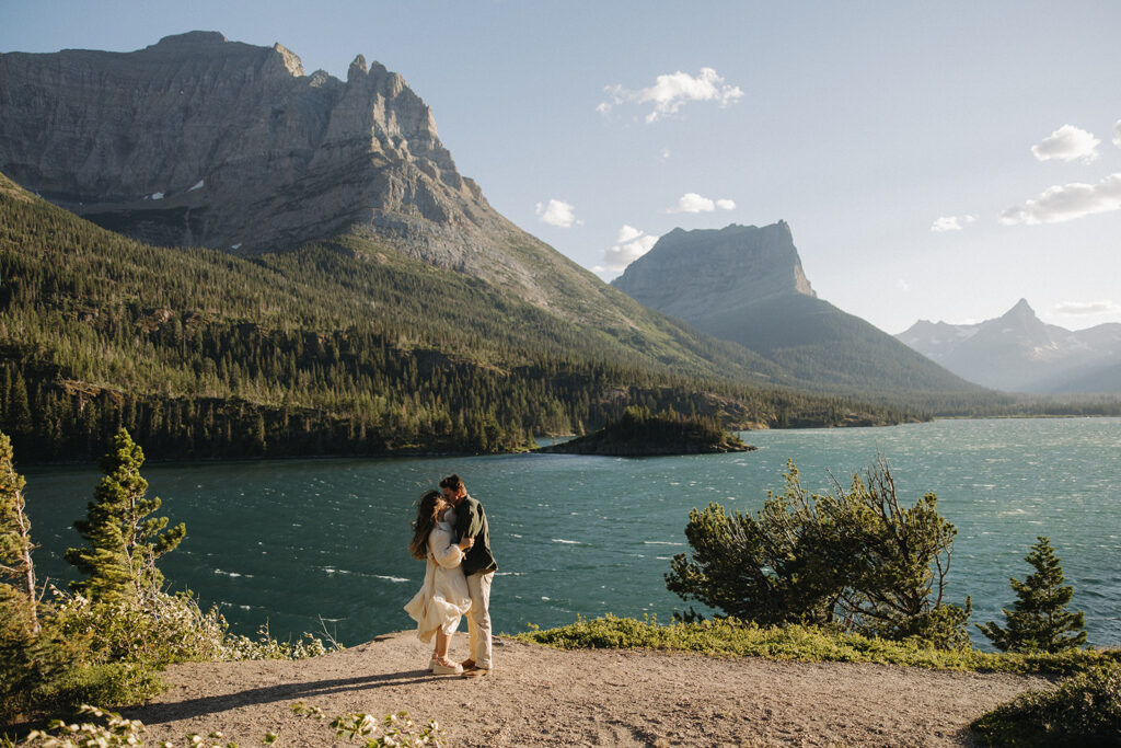 couple kisses at windy Glacier National Park engagement
