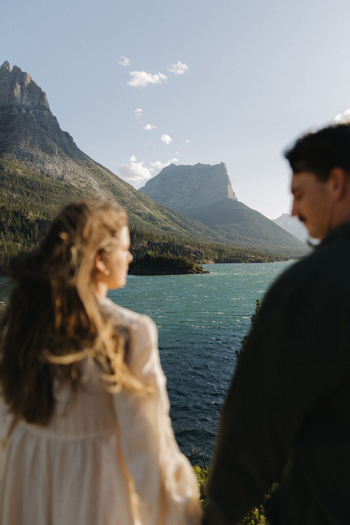 couple holds hands at windy at Glacier National Park engagement