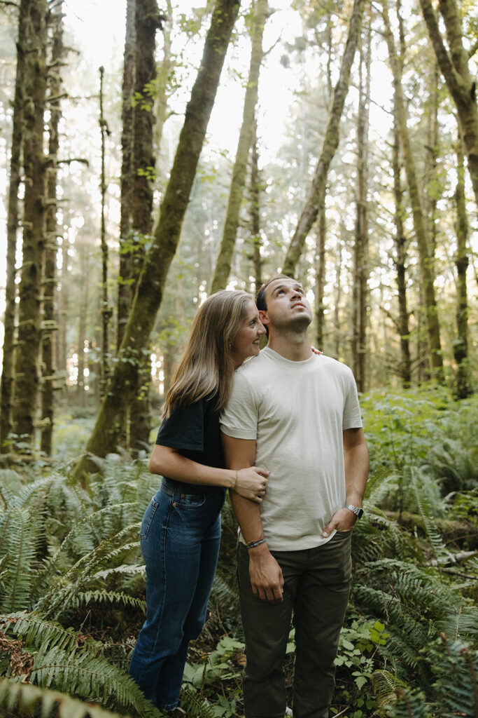 couple embraces in sunset woods engagement session