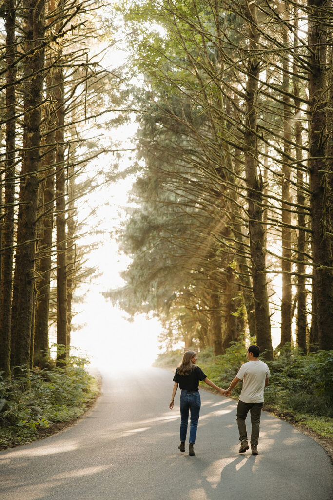 couple walks holding hands through sunset woods