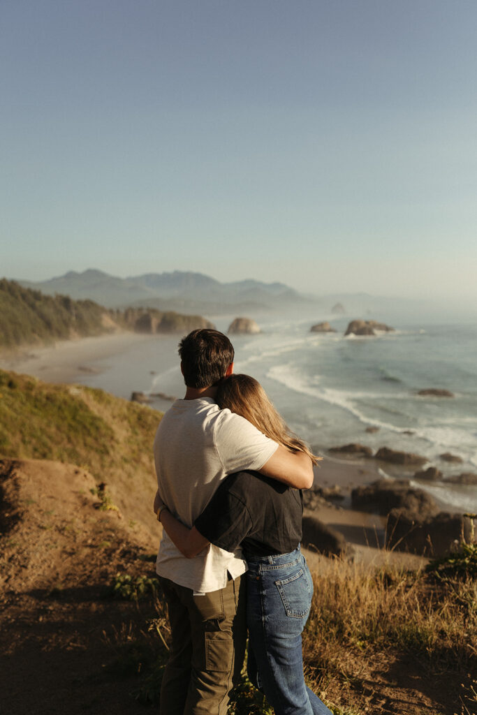 couple embraces overlooking Oregon coast 