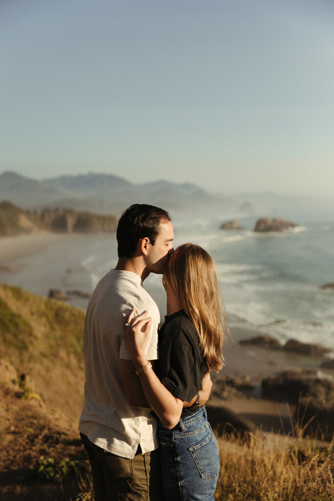 couple kisses overlooking Oregon coast 