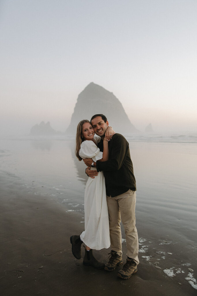couple embraces at Cannon Beach sunset engagement session