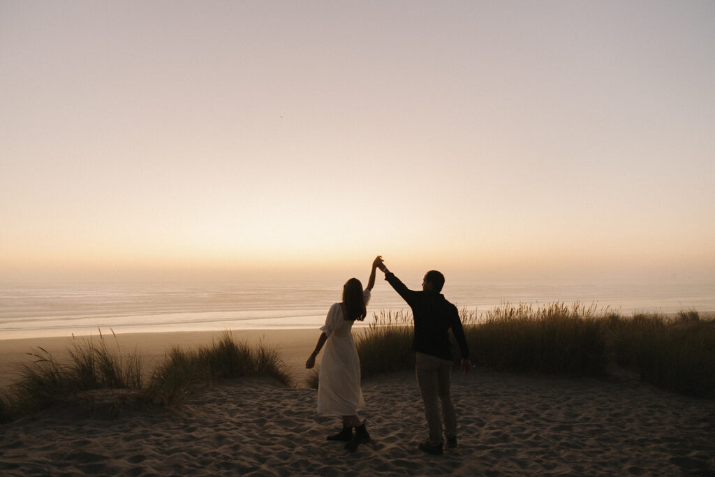 couple twirls at Cannon Beach sunset engagement session