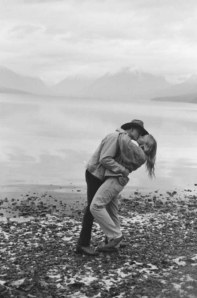 couple kisses beside lake with film photography on 35mm