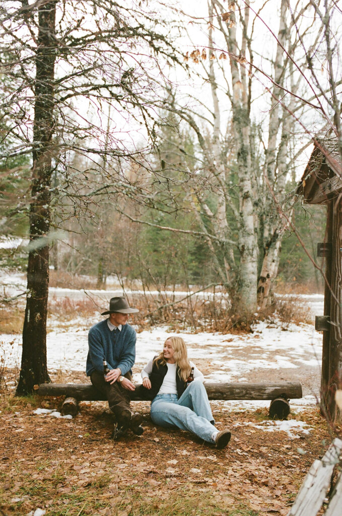 couple embraces in snowy woods with film photography on 35mm