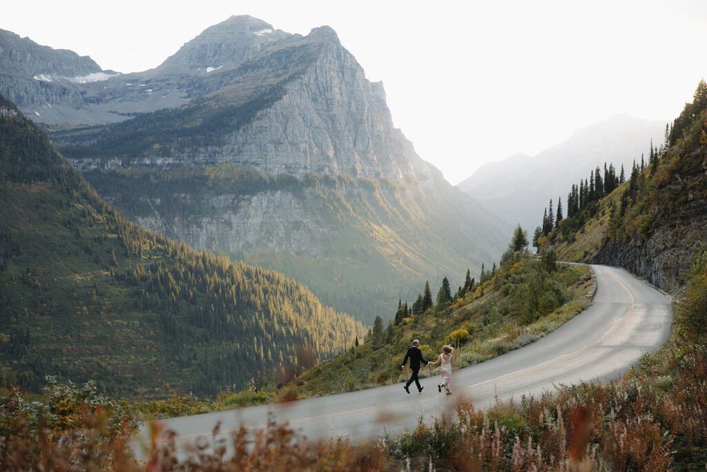 Couple runs on road in Glacier National Park