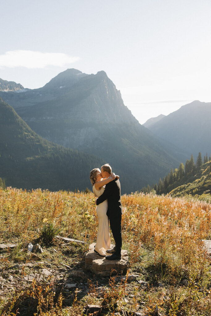 Couple stands on rock in Glacier National Park