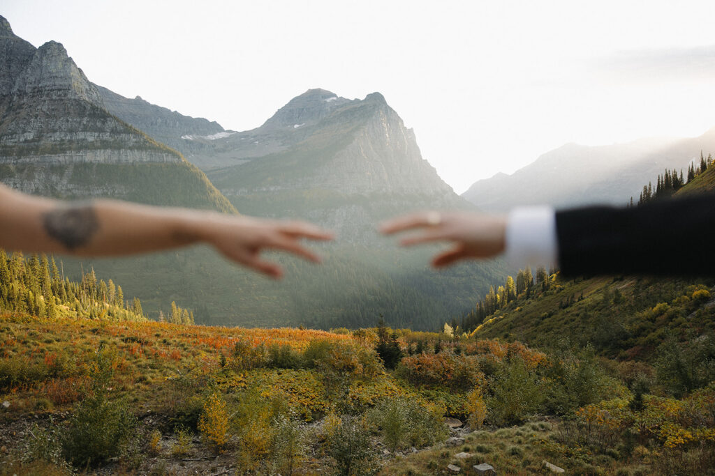 Couples hands extend in Glacier National Park